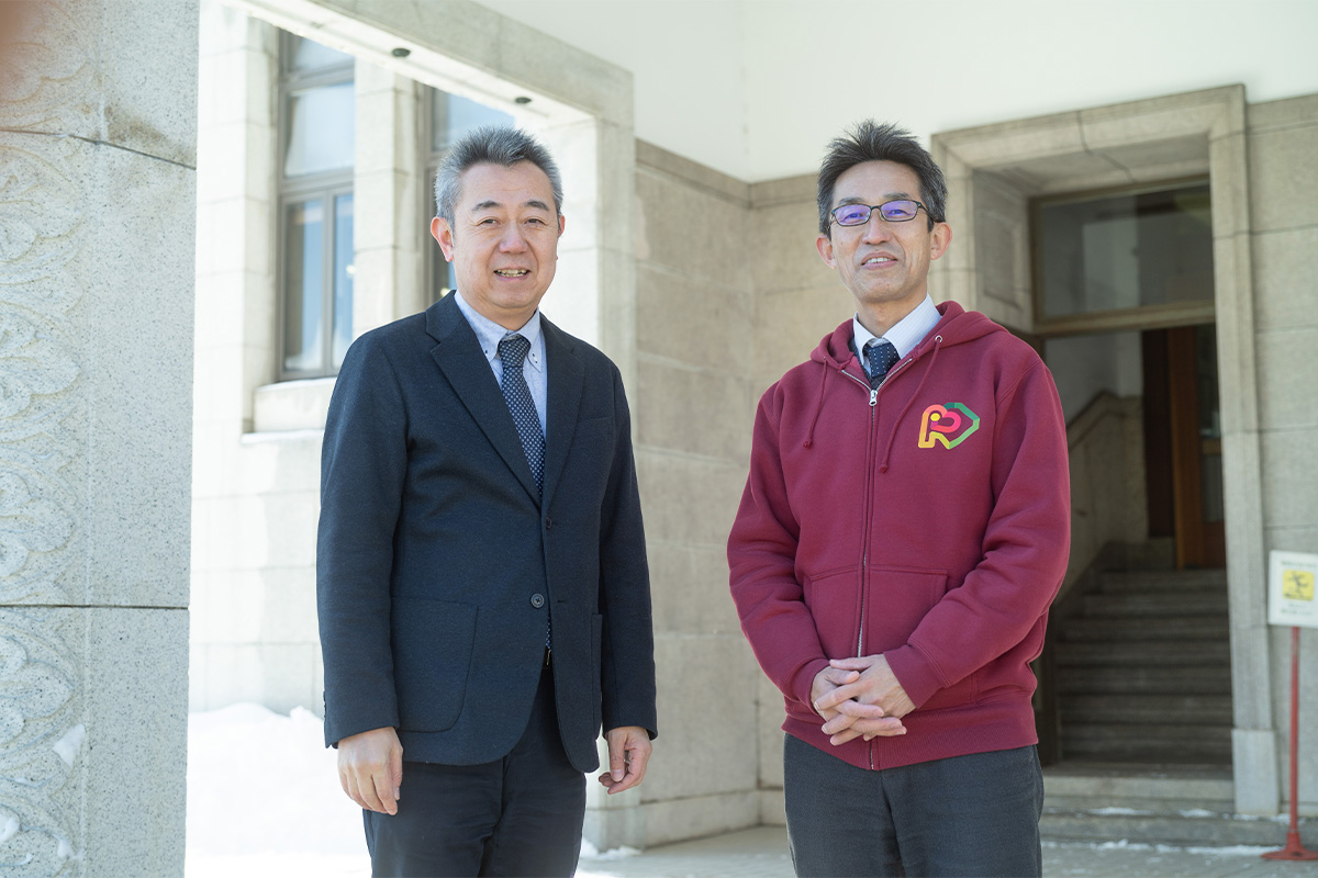 小樽市産業港湾部長・渡部一博さん（左）と産業港湾部観光振興室の松本貴充さんの写真。